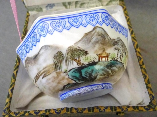 Egg shell porcelain Oriental octagonal bowl depicts mountain scene and comes with storage box. Bowl