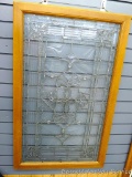 Unique leaded glass window is mounted in a wooden frame. Measures approx 23