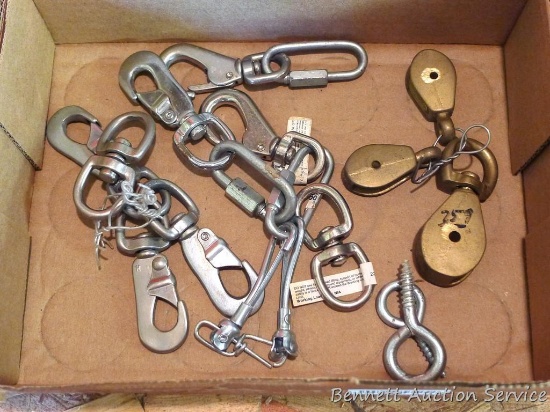 Assortment of metal clips 5" long; three brass pulleys.