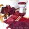 Cranberry bathroom accessories including several throw rugs, tissue box cover, wastebasket, two side
