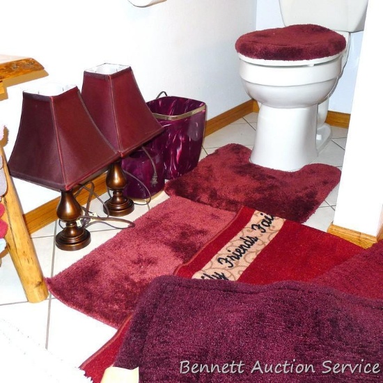 Cranberry bathroom accessories including several throw rugs, tissue box cover, wastebasket, two side