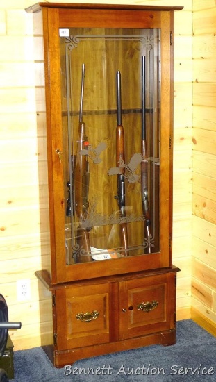 Wooden gun cabinet with two locking storage areas and etched glass door is approx. 29" x 11" x 72"