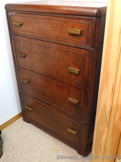 Antique four drawer dresser has dovetailed drawers and what we think is black walnut veneer. Piece