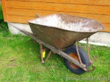 Heavy duty old wheelbarrow has weathered wood.