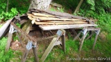Hardwood lumber had been covered by tar paper, but has seen some rain. Four saw horses. Everything