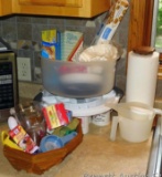 Cake keeper, paper towel holder, food coloring, measuring cups, parchment paper, cups, ash tray