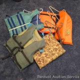 Five life vests or flotation devices. One adult medium, one adult universal, more.