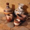 Little painted clay vases, bowl and pitcher. Also stone 'broadhead' shaped piece. Vases are approx.