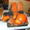 Assortment of chainsaw parts and safety equipment including chains, saw parts, chain covers, hard