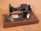 Vintage New England Queen sewing machine mounted on wooden base. Measures 19