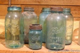 Collection of 6 green glass jars including ball and Fruit Keeper. One glass top and one metal top