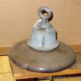 Large porcelain insulator. Top metal portion is marked with a 'B' and 'Hydro'. Stands approx. 9