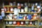 Four shelves of partial coffee cans containing drywall screws, carriage bolts, roofing nails, more.