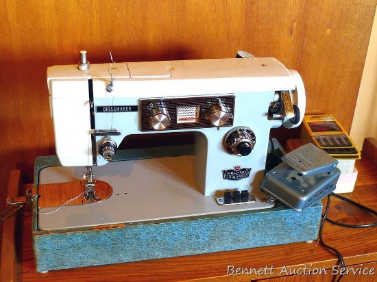 Vintage De Luxe dressmaker portable sewing machine with manual. Looks to be in good condition.