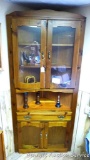 Nice corner curio cabinet with storage and a few contents. Cabinet stands 81