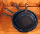 Four smaller cast iron skillets. Three are 8
