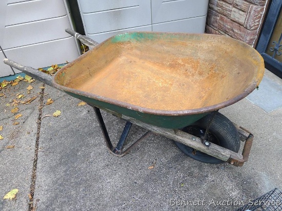 Wheel barrow has a 3' tub that is in good condition, handles are weathered. Tires is up.