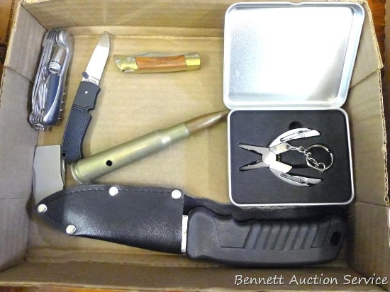 Pocket knives, hunting knife, and a keychain utility knife, .50 caliber BMG training round. Sheathed