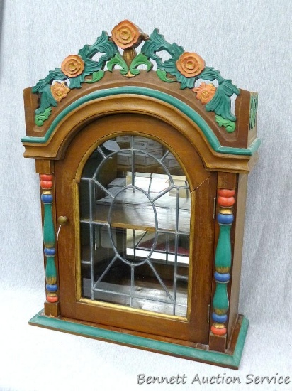Carved wooden display cabinet has a leaded glass window. Measures about 18" x 7" x 25". Has shelf
