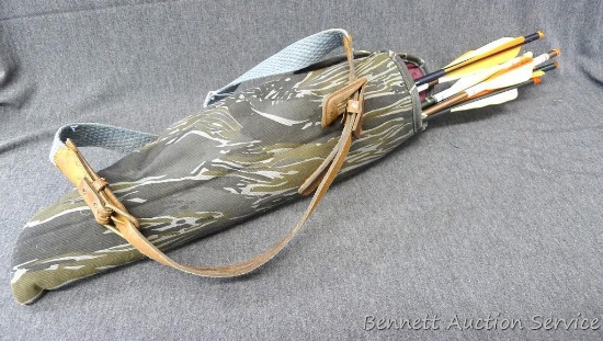 Camo cloth quiver with 7 crossbow bolts that have field points and broadheads.