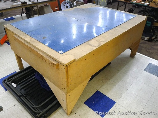 Homemade wooden work table is 71" x 48" x 31" tall. Sturdy table has plexiglass on top, appears they