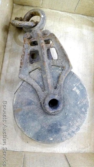 Cast iron pully has wooden wheel; measures 11-1/2" 5-1/2" x 4".