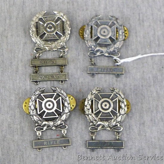 Four US Army Marksmanship Qualification Expert Badges. Each badge includes a Rifle clasp.