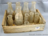 Glass milk bottles; includes five 1 quart and four half pints in a wooden crate. Oneida Milk