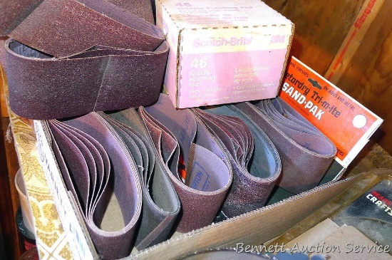 Dozens of 3" x 18" sanding belts, plus a full box of ScotchBrite pads.