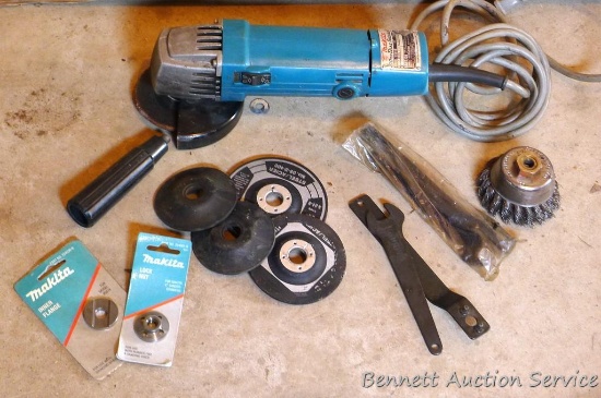 Makita 4" angle grinder with extra arbor nut and wire cup wheel.