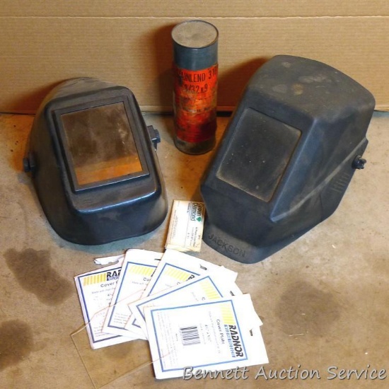 Two large lens welding helmets, extra cover plates and a sealed can of Stainlend 316 welding rod,