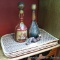 Two decorative wine decanters; neat corkscrew; five woven wicker placemats. Taller decanter is