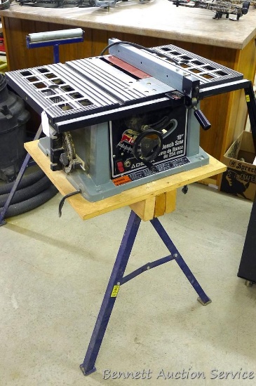 Delta 10" table saw K9533 with fence. Wooden base sits on included saw horse. Stands 41" tall