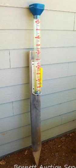 Acurite rain gauge mounted on wood.