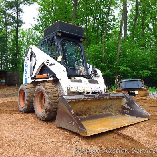 Watch the video.  Bobcat 773 skid steer loader comes with a 5'8" bucket and enclosed cab.
