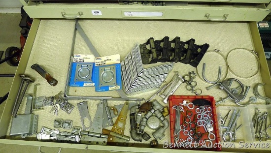 Contents of drawer includes hinges, hasps, ring pulls, hooks, muffler clamps, galvanized pipe