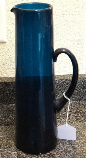 Hand blown aqua glass pitcher stands 13" tall. No chips noted.