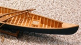 Wooden model canoe on a stand. Canoe is 27