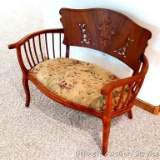 Wonderful antique love seat has curved arms and back, cut design to accent the back rest, applied