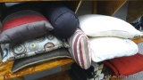 Six assorted throw pillows, plus a smaller memory foam pillow. All are in good condition.