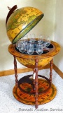 Mini bar resembles a globe on a stand. Top lifts to show a set of eight wine glasses with a cut