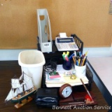Office supplies including desk top file organizers; adding machine; cups of pens, highlighters,