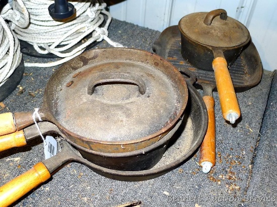 5 cast iron skillets and pots have wooden handles. Includes a 20 oz saucepan, a 1 qt pot, 10"