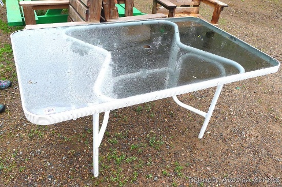 Glass-topped patio table is about 37" x 61" x 28" high. Patio umbrella is lot number 107.