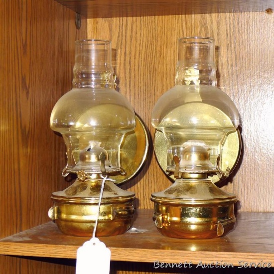 Two wall mountable brass toned oil lamps are each approx. 10-1/2" tall.