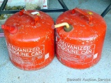 Two five gallon gas cans. Vent hole on one has been plugged with a screw.