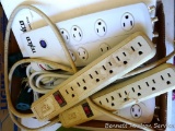 Two surge protectors, two power strips and two three way plug-in adaptors.