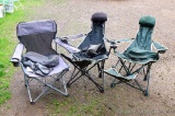 Two folding lounge chairs and one folding camp chairs with bags. One lounge chair is Ozark Trail