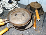 5 cast iron skillets and pots have wooden handles. Includes a 20 oz saucepan, a 1 qt pot, 10