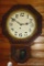 Antique key wound wall clock has an oak frame that is 2' tall. Main drive winds and holds, clock